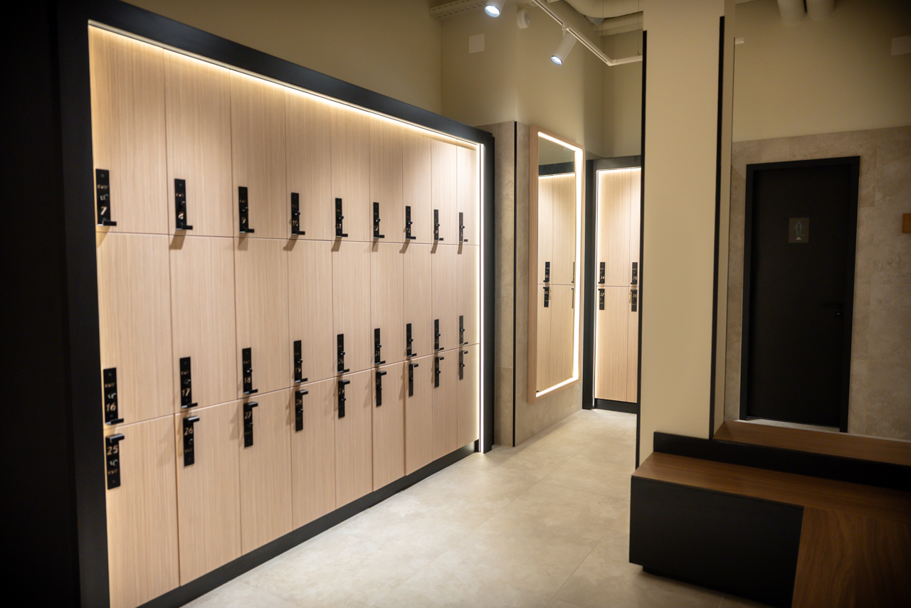Modern changing room with lockers, mirrors and benches at EVO Zurich Dubendorf